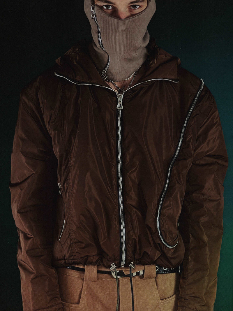 The Water Resistant Brown Nylon Outer jacket from RÊVEUR LUCIDE, made in Paris, France. This jacket features ‘R L’ paneling, oversized ‘L’ pocket, and a zipper pocket on the front right. With a wadding shell of polyester/cotton twill, Raccagni zippers, and an Atelier patch on the back, this jacket is both stylish and functional. The relaxed cropped fit is true to size.